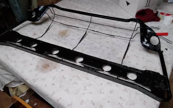Trimming Department - Large seat frame after being sprayed black - AM Restoratiions